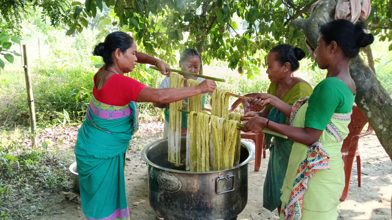 Artisan women dyeing yarn by hand with botanical colour