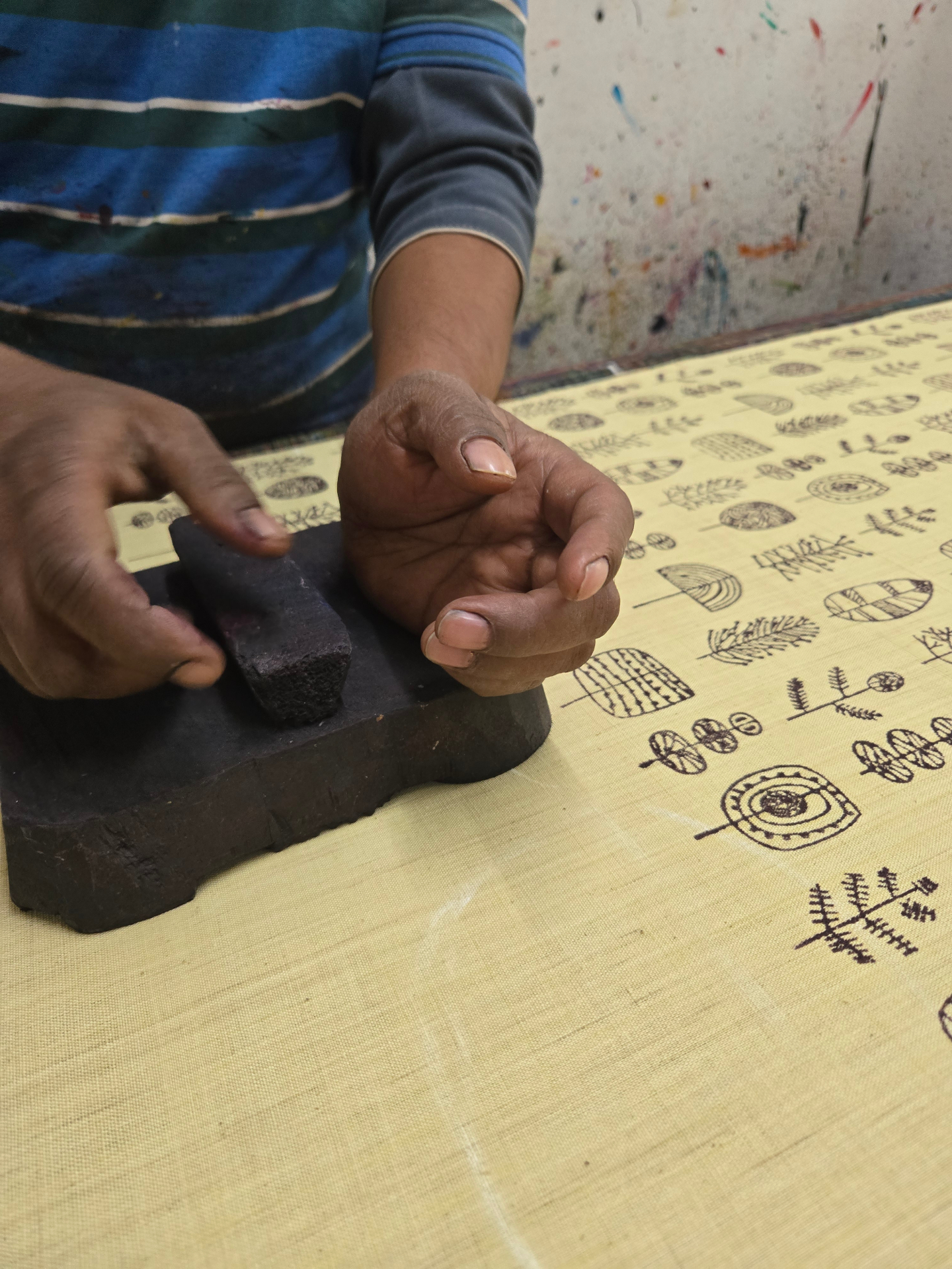 An artisan hand block-printing naturally dyed heritage fabric